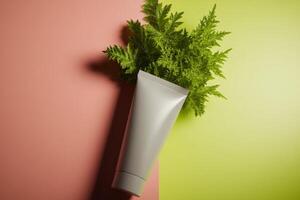 Creative arrangement of a tube and fresh green leaves on contrasting colorful background photo