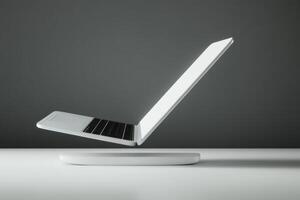 Laptop hovering above a sleek base showcasing modern technology in a minimalist setting photo