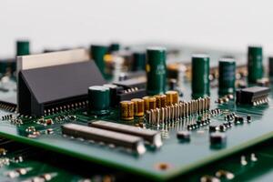 Close-up view of a printed circuit board featuring capacitors, resistors, and connectors arranged on the green surface photo