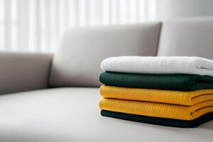 Stack of neatly folded towels in a bright living room on a cozy couch photo