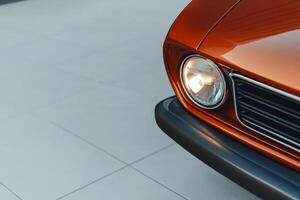 Classic car in striking orange color parked on shiny tile floor during daylight hours photo