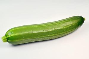 A cucumber is shown on a white surface photo