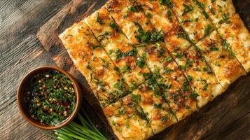 A flatbread with cheese and herbs on a wooden cutting board photo