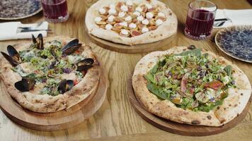 Gourmet Pizzas with Seafood and Greens on a Wooden Table video