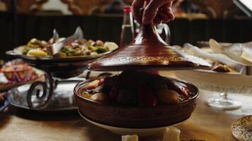 Opening a steaming tagine pot at a festive table video