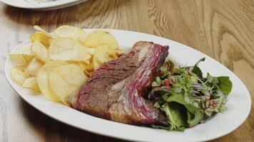 Grilled beef steak with potato chips and salad video