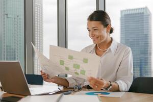 A businesswoman is diligently reviewing important documents at her modern office space photo