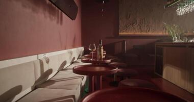 Wine bottle with wineglass placed on small red round table in bar video
