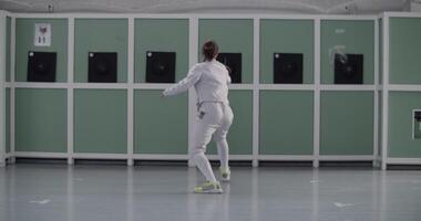 Anonymous fencer practicing in gym alone video