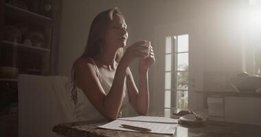 Female composer drinking delicious coffee while composing music at home video