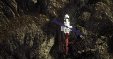 Helicopter hovering above rocky terrain in a remote location video