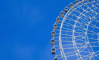 white big Ferris wheel on background a blue sky in amusement park at fair in summer with copy space photo