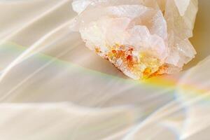 Quartz clear stone with Rainbow Beam at sunlight, bright sun glare and flare, beige blur background. Shiny magic crystal make caustic and light effects at sunshine, harmony and beauty of nature photo