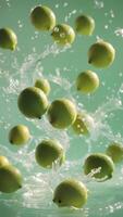 a group of lemons falling into water with a green background photo