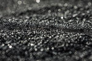 Glittering macro close-up of black sand with bokeh effect photo