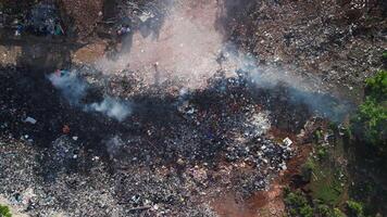 Burning illegal dump with smoke in Bali. Pollution by plastic rubbish on landfill, aerial view. video