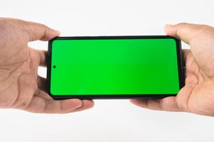 Hands Holding Smartphone with Green Screen for Technology or Display Mockup photo