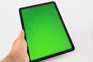 Hand Holding Modern Tablet with Green Screen Display and Stylus Attached photo