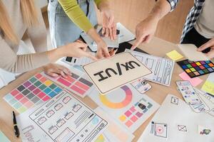 Diverse team presenting UXUI designs and discussing project direction in office. photo