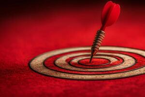 Red dart perfectly hitting the bullseye on target photo