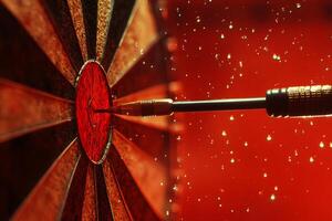 Dart striking bullseye with red sparkles photo