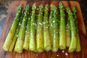Fresh asparagus spears with sea salt on wooden board photo