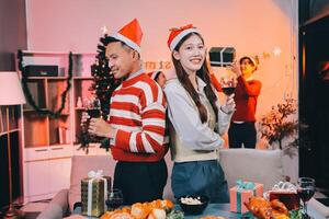 A couple in christmas clothes standing in front of a table with food photo