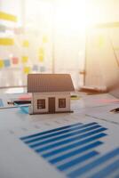 House model on desk with graphs and papers photo