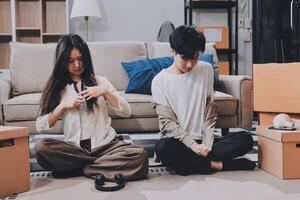 A couple sitting on the floor with boxes photo