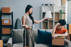 A woman is holding a box while a man is sitting on a couch photo