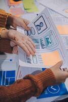 personas trabajando en un proyecto con papel y pegajoso notas foto