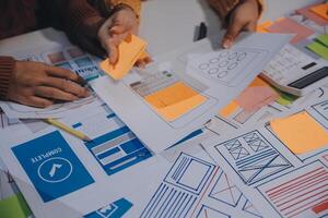 A group of people working on a project with paper and sticky notes photo