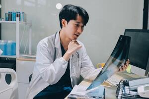 A man in a lab coat is looking at a x - ray photo