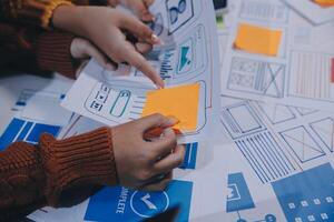 A group of people working on a project with paper and sticky notes photo