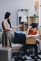 A man and woman are sitting on a couch with a suitcase photo