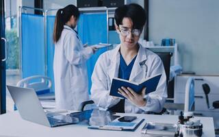 A man in a lab coat is reading a book photo