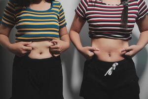 Two women with their stomachs showing photo