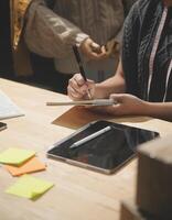A person is writing on a tablet while sitting at a desk photo