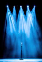 Minimalist conference stage featuring a microphone stand set against a dark background illuminated by soft blue lighting photo