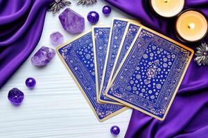 Mystical tarot card reading setup with deep violet silk cloth, glowing candles, and shimmering crystals surrounding an open tarot deck for spiritual exploration and insight photo