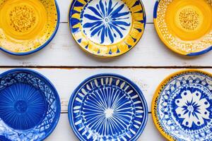 Vibrant Mediterranean ceramics featuring hand-painted plates with intricate patterns in warm earthy tones showcasing artisan craftsmanship from the region photo