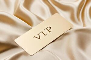 Golden access card placed on luxurious silk fabric, creating a sense of exclusivity and prestige for elite members of a distinguished club photo