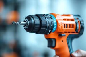 Close-up of orange and black cordless drill holding a drill bit photo