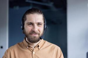 Professional customer support agent wearing a headset, smiling warmly in a modern workplace setting. photo