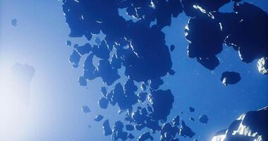 Mysterious rocky formations floating in deep blue space during sunlight video