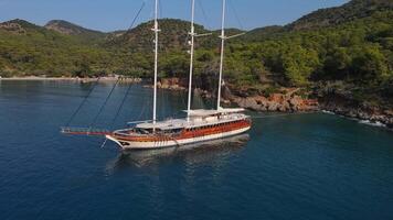 Aerial. yacht anchored in a bay surrounded by trees and mountains video
