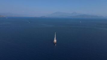 Aerial. Sailboat is sailing in the ocean with a clear blue sky in the background video