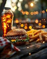 A hamburger and fries on a table with a drink photo