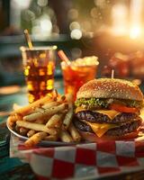 A hamburger and fries on a table with a drink photo