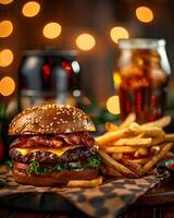 A hamburger and fries on a table with a beer photo
